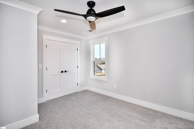 empty room with visible vents, baseboards, ceiling fan, ornamental molding, and carpet