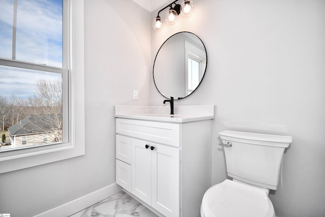 half bath featuring toilet, marble finish floor, baseboards, and a wealth of natural light