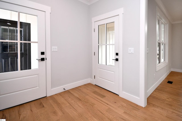 entryway with baseboards, visible vents, and light wood finished floors