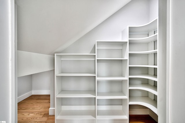 walk in closet featuring lofted ceiling and wood finished floors