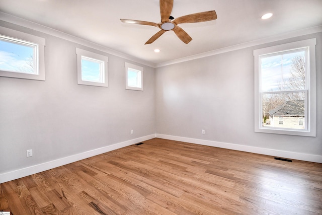 unfurnished room featuring a healthy amount of sunlight, baseboards, and crown molding