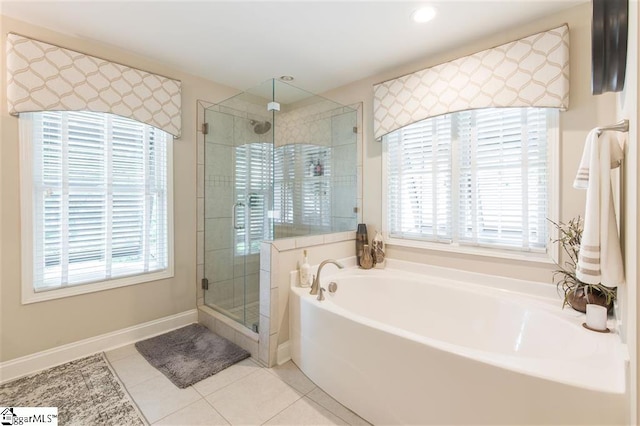 bathroom with a stall shower, tile patterned flooring, a bath, and baseboards