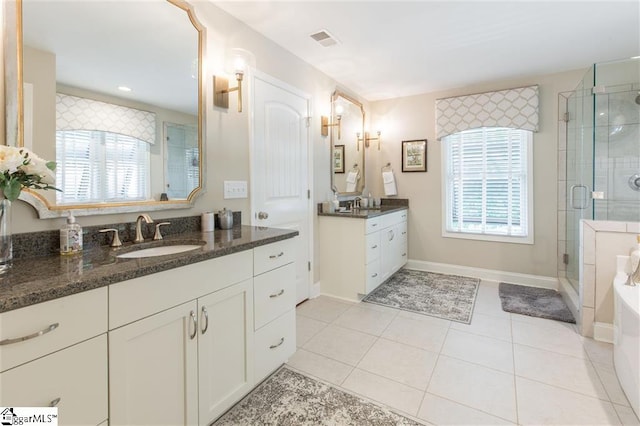 bathroom with a wealth of natural light, visible vents, a sink, and a shower stall