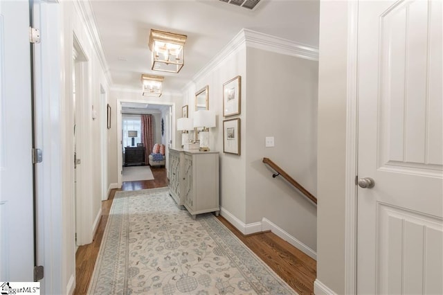 corridor featuring light wood-type flooring, baseboards, crown molding, and an upstairs landing