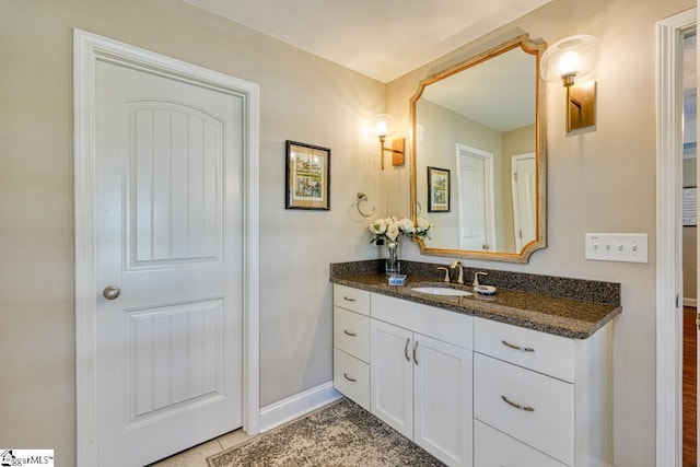 bathroom with tile patterned flooring, vanity, and baseboards