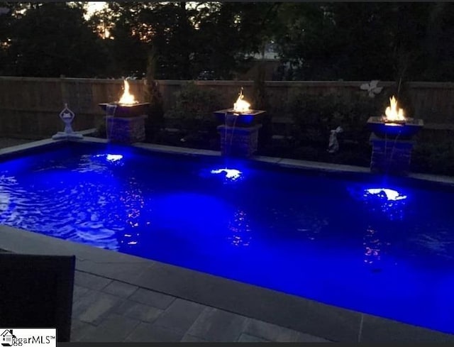 view of pool with a fenced in pool, an outdoor fire pit, and a fenced backyard