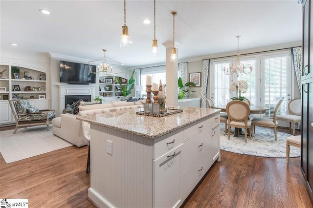 kitchen with dark wood-style flooring, a fireplace, and a notable chandelier