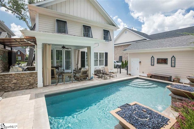 back of property featuring a patio, area for grilling, board and batten siding, ceiling fan, and an outdoor pool