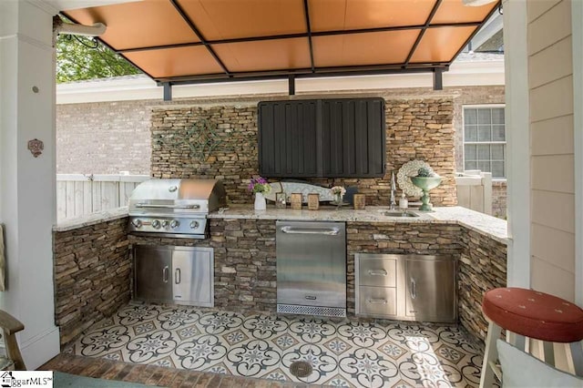 view of patio / terrace with a sink, an outdoor kitchen, and a grill