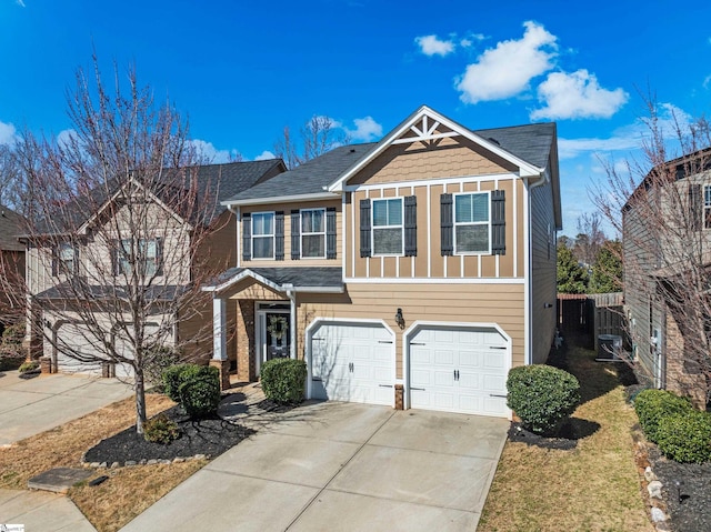 view of front of property featuring a garage, driveway, and fence