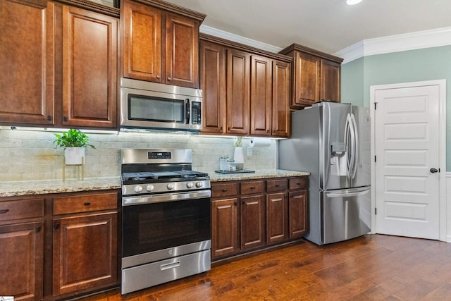 kitchen featuring stainless steel appliances, dark wood-type flooring, ornamental molding, light stone countertops, and tasteful backsplash