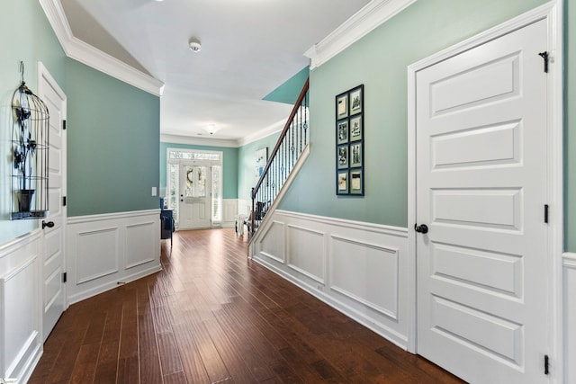 entrance foyer with stairs, ornamental molding, dark wood-style flooring, and wainscoting