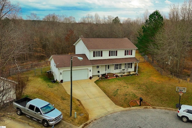 view of front of home featuring a garage, driveway, covered porch, fence, and a front lawn