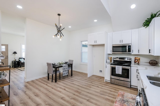 kitchen featuring appliances with stainless steel finishes, white cabinets, and light wood finished floors