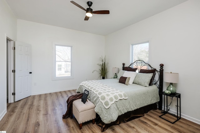 bedroom with ceiling fan, baseboards, and wood finished floors