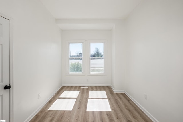 spare room featuring wood finished floors and baseboards