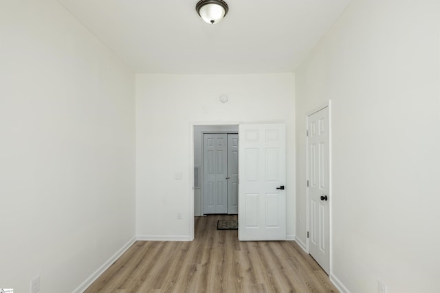 interior space with baseboards and light wood finished floors