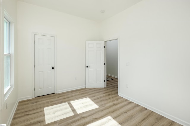 unfurnished bedroom with light wood-type flooring and baseboards