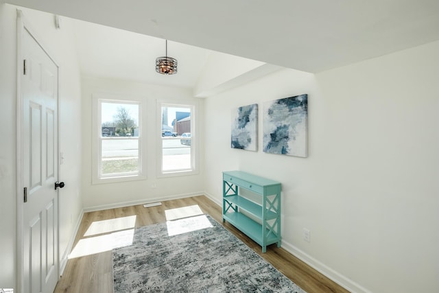 interior space with lofted ceiling, light wood-style flooring, and baseboards