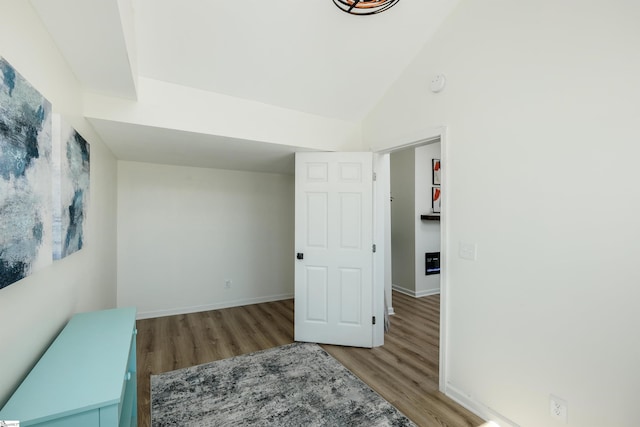 bedroom featuring vaulted ceiling, baseboards, and wood finished floors