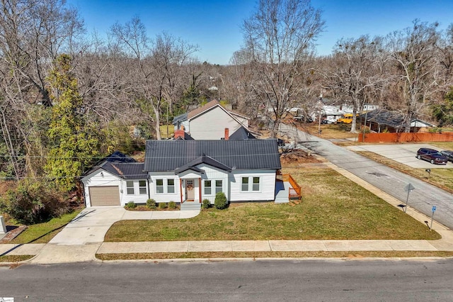 traditional-style home featuring a garage, a front yard, and driveway