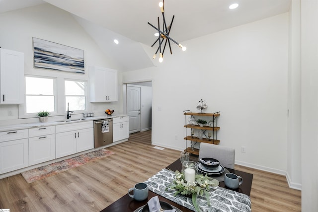 kitchen featuring a sink, white cabinetry, light wood-style floors, light countertops, and stainless steel dishwasher