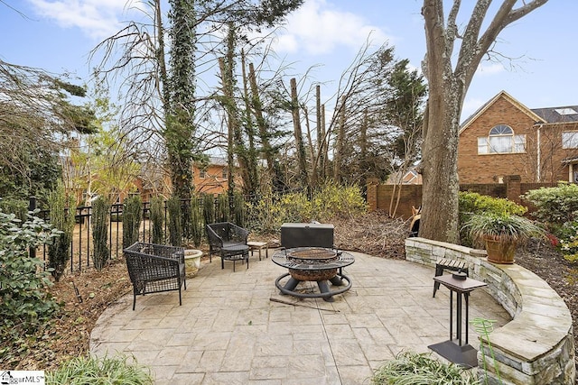 view of patio featuring fence and a fire pit