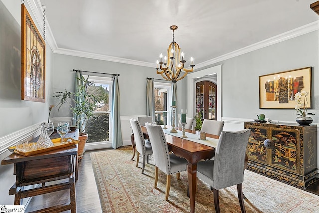 dining space featuring an inviting chandelier, crown molding, and wood finished floors