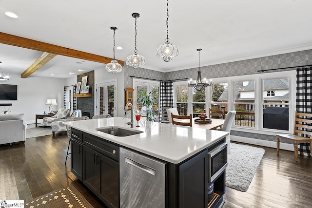 kitchen with wallpapered walls, open floor plan, stainless steel appliances, french doors, and a sink