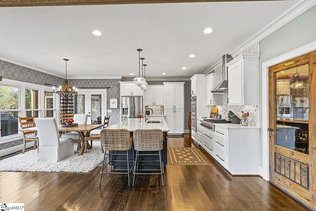 kitchen with ornamental molding, stainless steel appliances, a sink, and light countertops