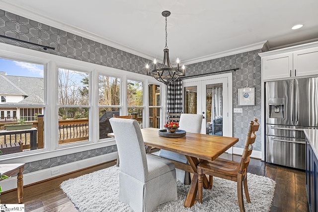 dining space featuring dark wood-style flooring, crown molding, baseboards, and wallpapered walls