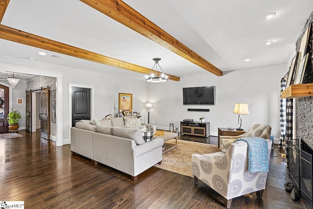 living area with a barn door, baseboards, beamed ceiling, dark wood finished floors, and an inviting chandelier