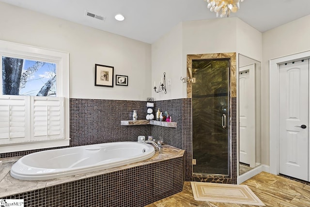 bathroom with tile walls, visible vents, a garden tub, and a shower stall