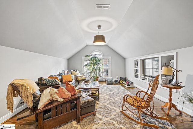 living room featuring baseboards, visible vents, vaulted ceiling, and wood finished floors