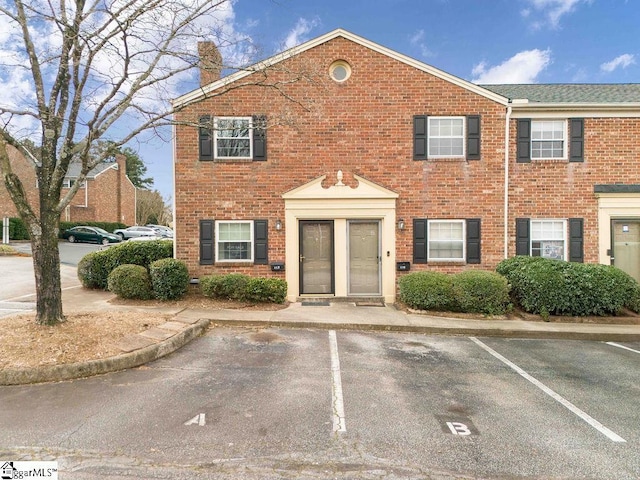 view of front of property featuring uncovered parking and brick siding