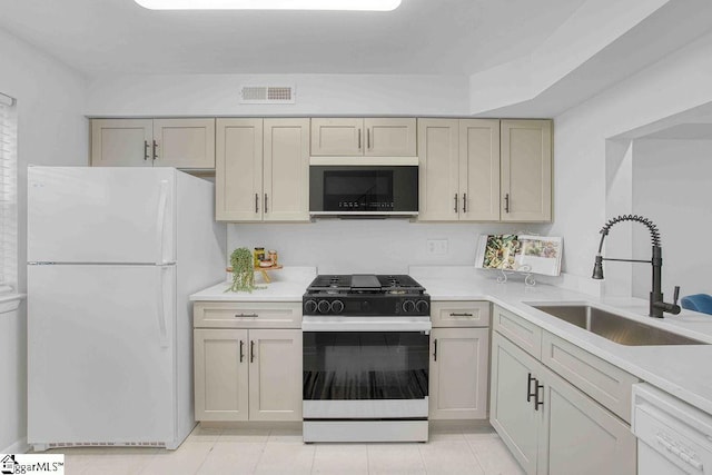 kitchen with white appliances, light tile patterned floors, visible vents, light countertops, and a sink