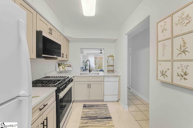 kitchen with light tile patterned floors, white appliances, a sink, a ceiling fan, and light countertops