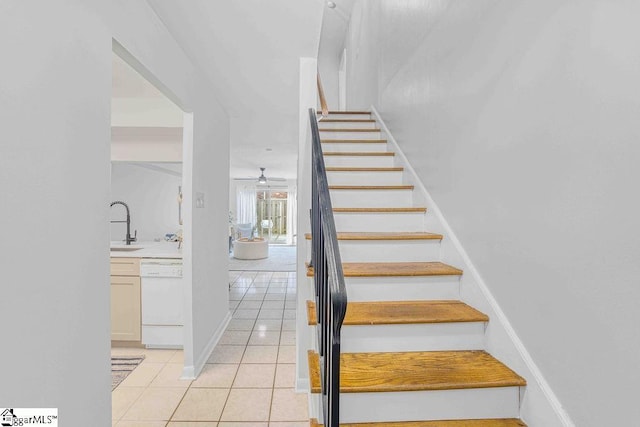 stairway featuring ceiling fan, baseboards, and tile patterned floors