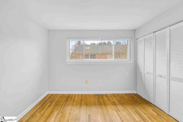 unfurnished bedroom with light wood-style floors, baseboards, and visible vents