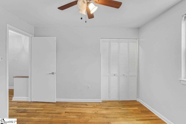 unfurnished bedroom with ceiling fan, a closet, wood finished floors, and baseboards