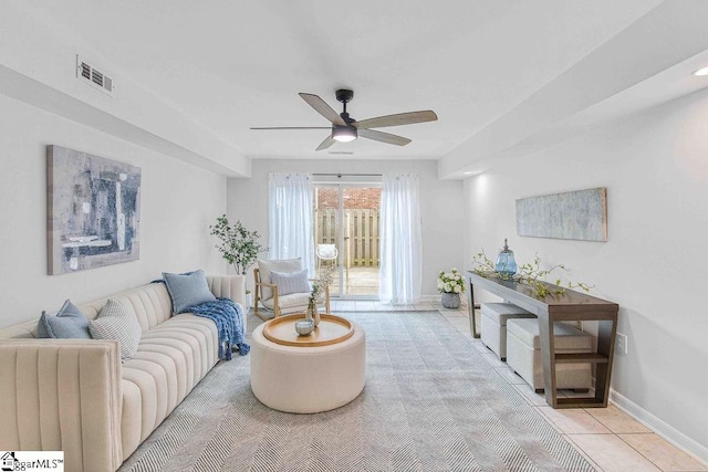 living room featuring a ceiling fan, light tile patterned flooring, visible vents, and baseboards