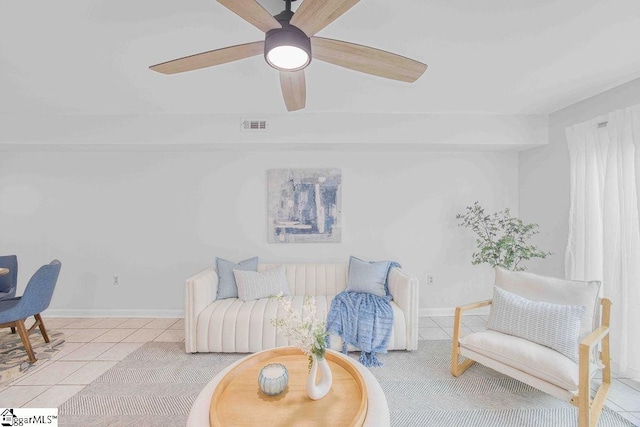 living area featuring light tile patterned floors, a ceiling fan, visible vents, and baseboards