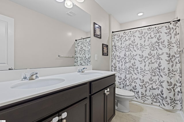 bathroom with visible vents, a sink, toilet, and double vanity