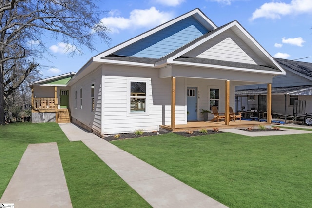 view of front of property featuring a porch, roof with shingles, and a front lawn