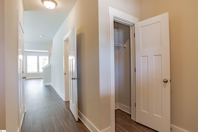 corridor featuring dark wood-style floors and baseboards