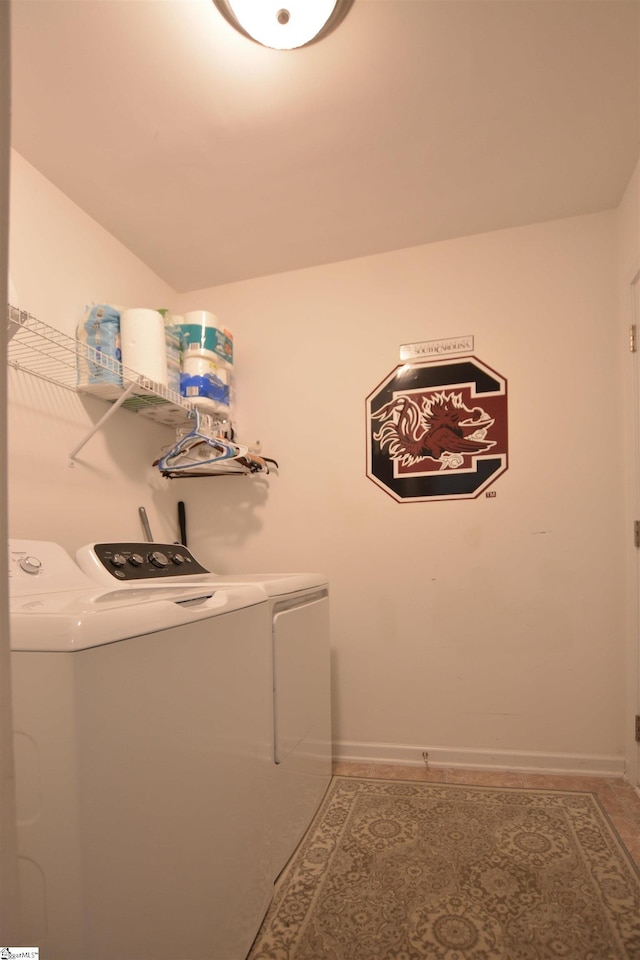 laundry area featuring tile patterned floors, laundry area, baseboards, and separate washer and dryer