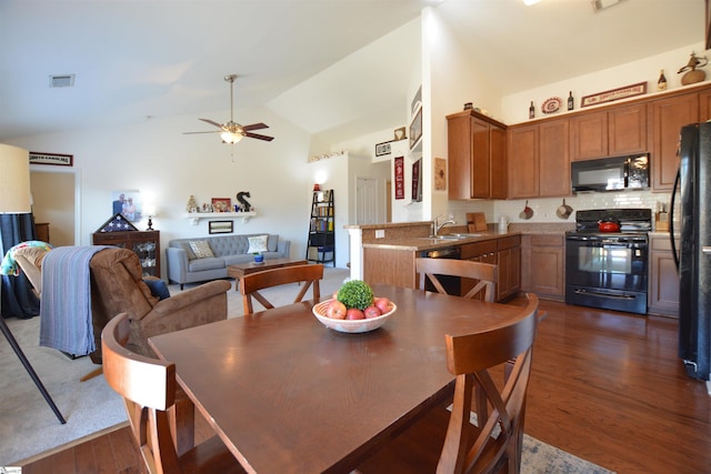 dining area featuring vaulted ceiling, dark wood-style flooring, visible vents, and a ceiling fan