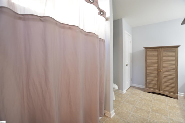 full bathroom with toilet and baseboards