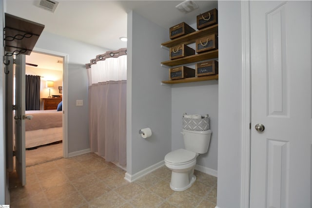 ensuite bathroom with connected bathroom, toilet, a shower with shower curtain, visible vents, and baseboards