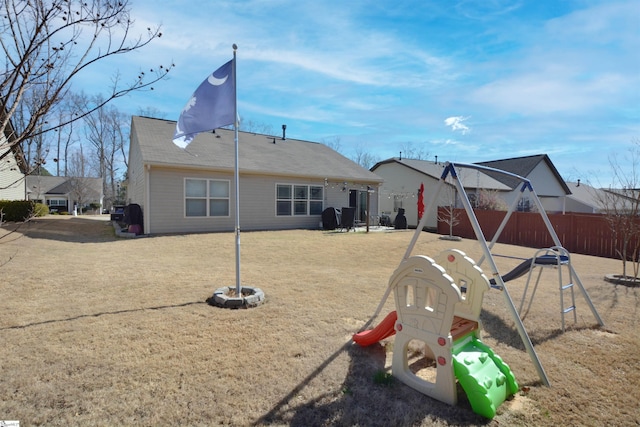 rear view of property featuring a playground